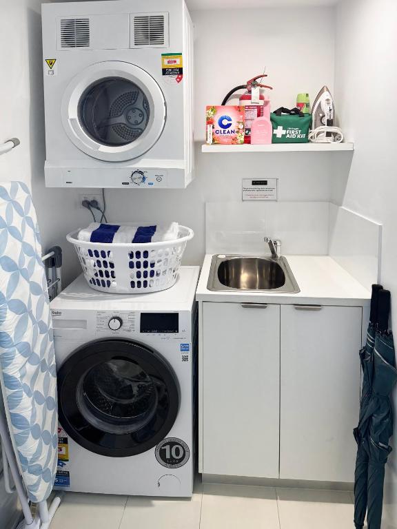 a small kitchen with a washing machine and a sink at Oracle 11th floor Tower 1 - GC Getaways in Gold Coast