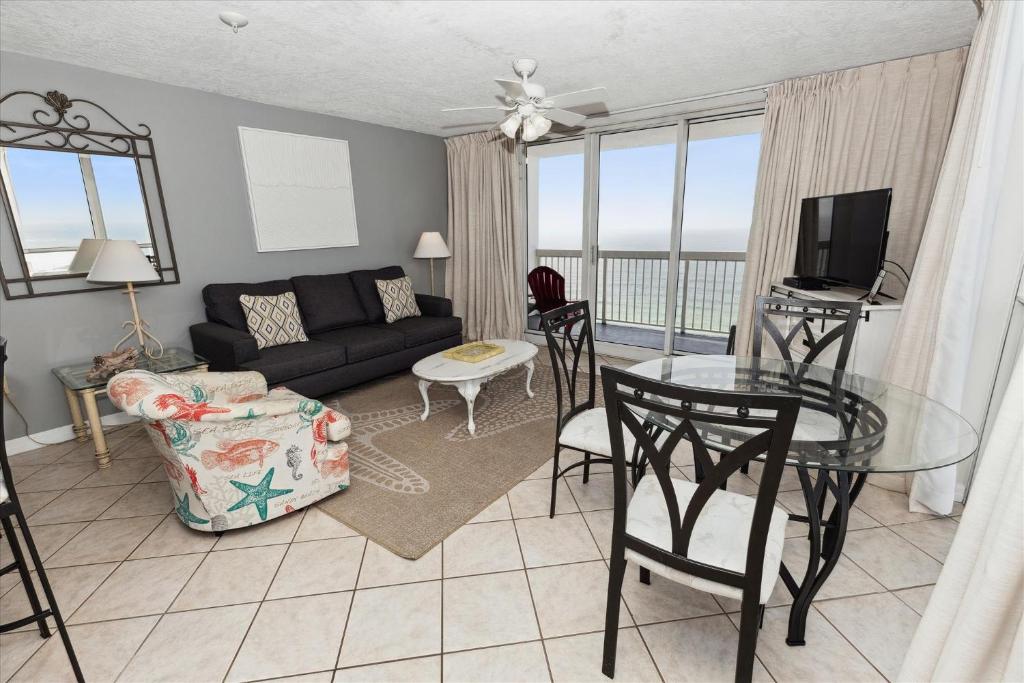 uma sala de estar com um sofá e uma mesa de vidro em Pelican Beach 1811 Destin Condo em Destin