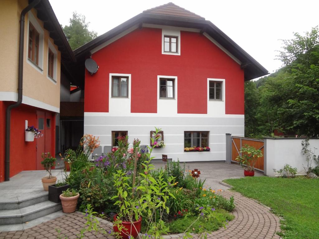 a red and white house with a garden at Frühstückspension Doris Eder in Gaming