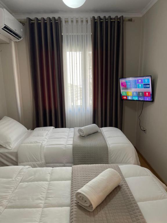 ein Hotelzimmer mit 2 Betten und einem Flachbild-TV in der Unterkunft Andi's Apartment 2 in Gjirokastër