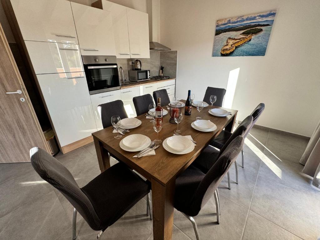 tavolo da pranzo con sedie nere e cucina di Apartman Mediteran a Šibenik
