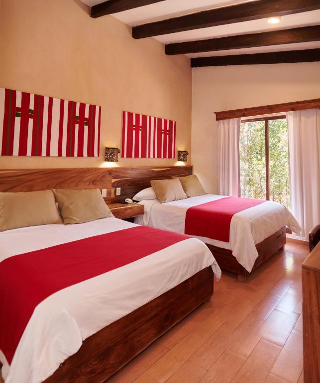 - une chambre avec 2 lits dotés de draps rouges et blancs dans l'établissement Hotel Mansion Del Valle, à San Cristóbal de Las Casas