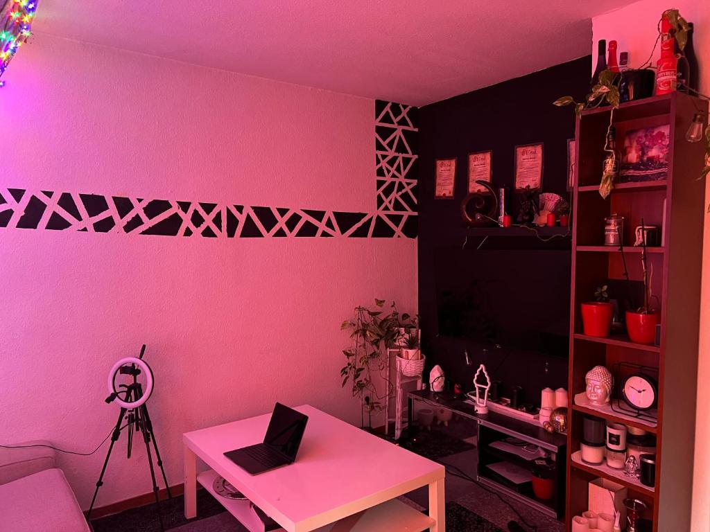 ein rosafarbenes Zimmer mit einem Tisch und einer rosa Wand in der Unterkunft Recharge in the wonderful heart of Cologne! in Köln