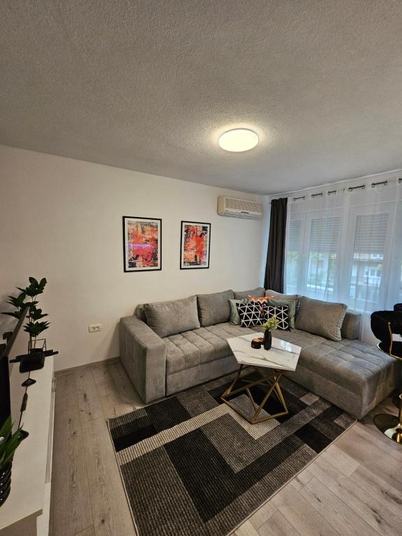 een woonkamer met een bank en een tafel bij Apartment Mia in Mostar