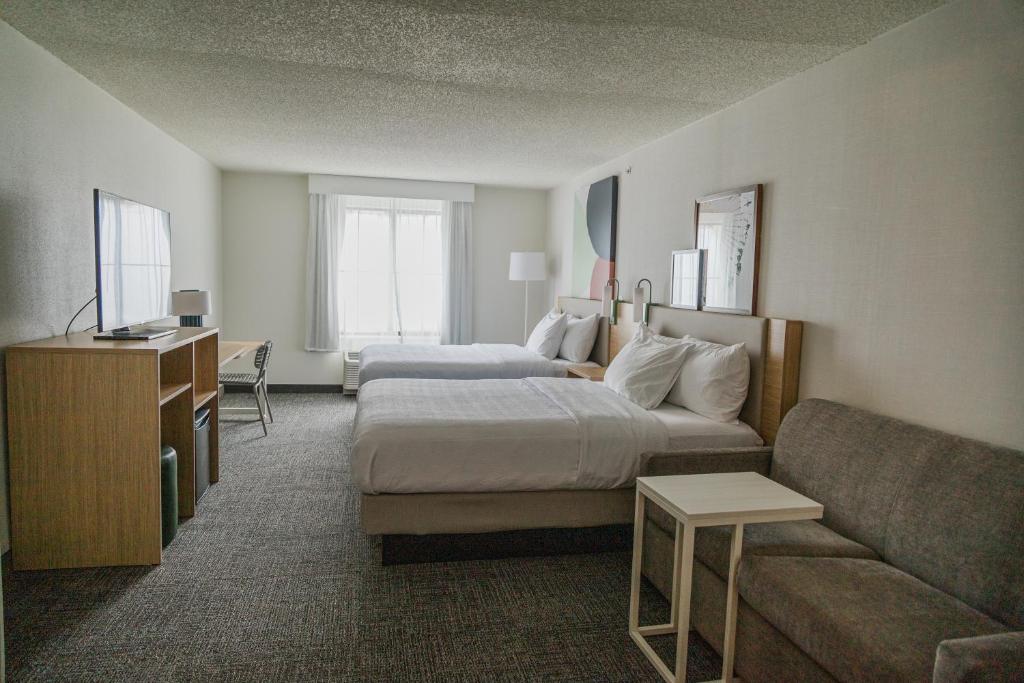 ein Hotelzimmer mit einem Bett und einem Sofa in der Unterkunft High Plains Hotel at Denver International Airport in Denver