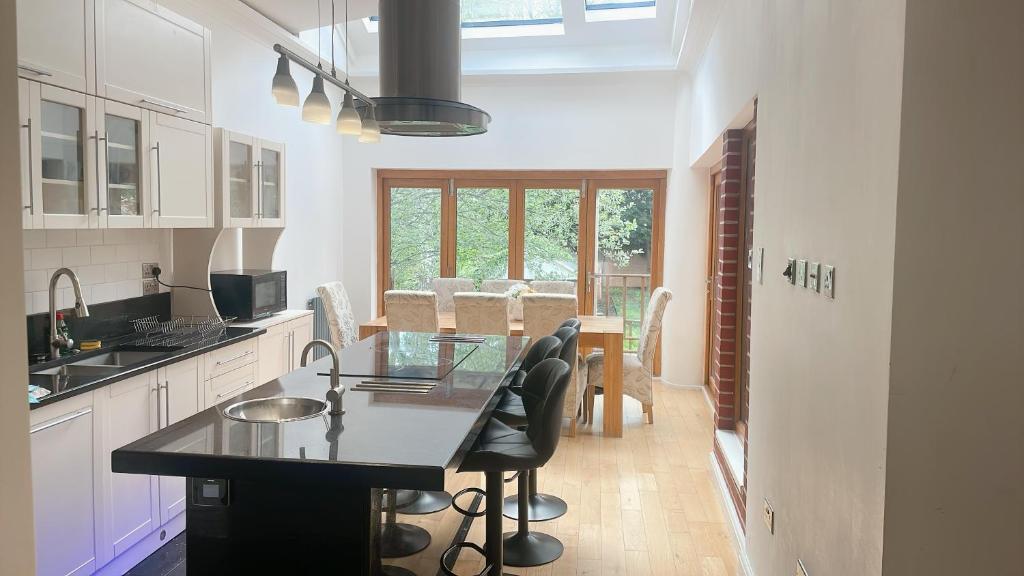 a kitchen with a table and chairs and a dining room at Stunning 5 Bed house with pool table and off street parking in Welling