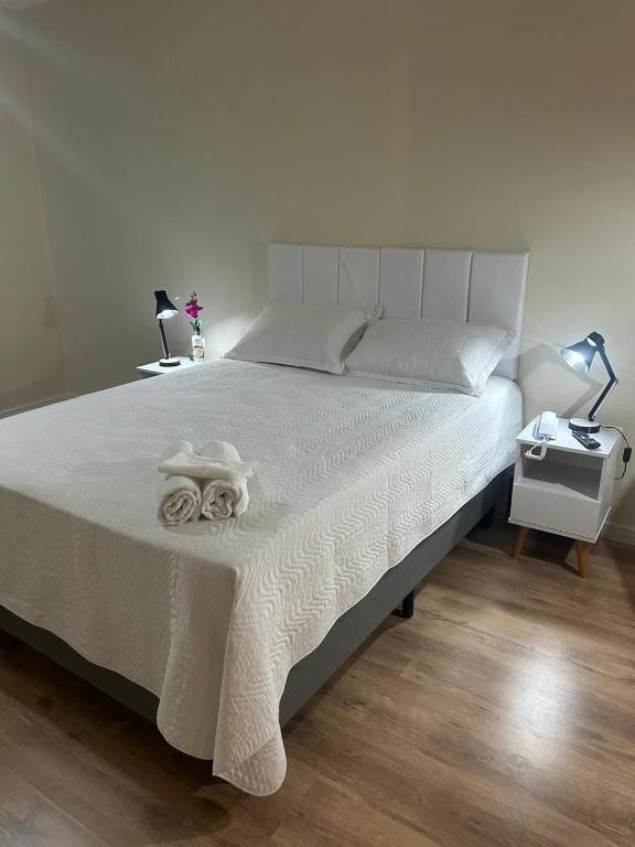 カンピーナスにあるAp Smart Hubのベッドルーム1室(白いベッドカバー付)