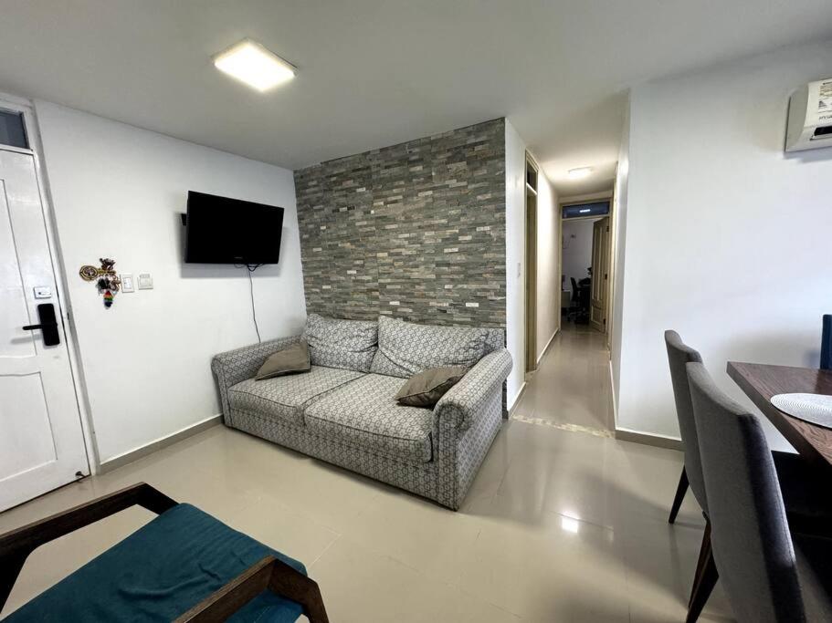 uma sala de estar com um sofá e uma parede de tijolos em Cozy Apt in Coveñas CCampestre em Coveñas