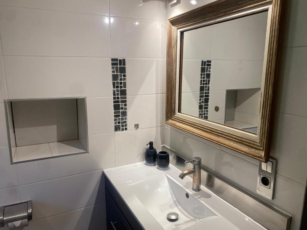 La salle de bains est pourvue d&#39;un lavabo et d&#39;un miroir. dans l&#39;établissement LE MASKALOU, à La Colle-sur-Loup