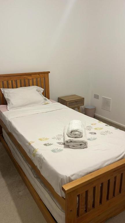 ein Bett mit einer weißen Decke und einem Handtuch darauf in der Unterkunft Sweet Home in Bristol