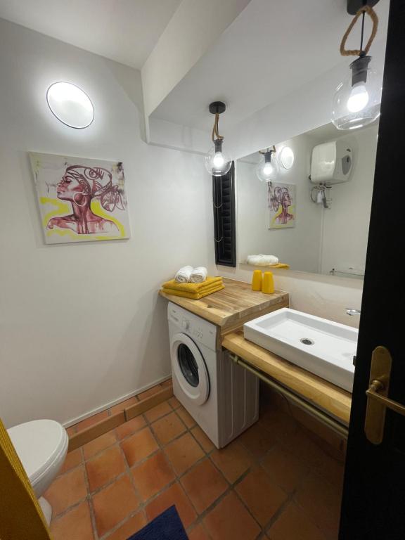 uma casa de banho com uma máquina de lavar roupa e um lavatório em Lever du soleil em La Trinité