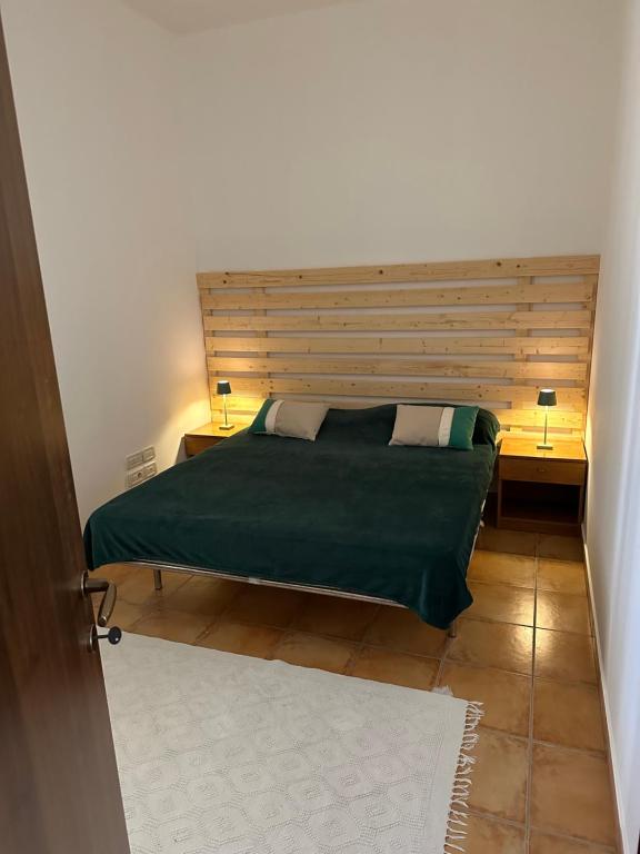 a bedroom with a bed with a wooden headboard at Casa Rosa in Elice