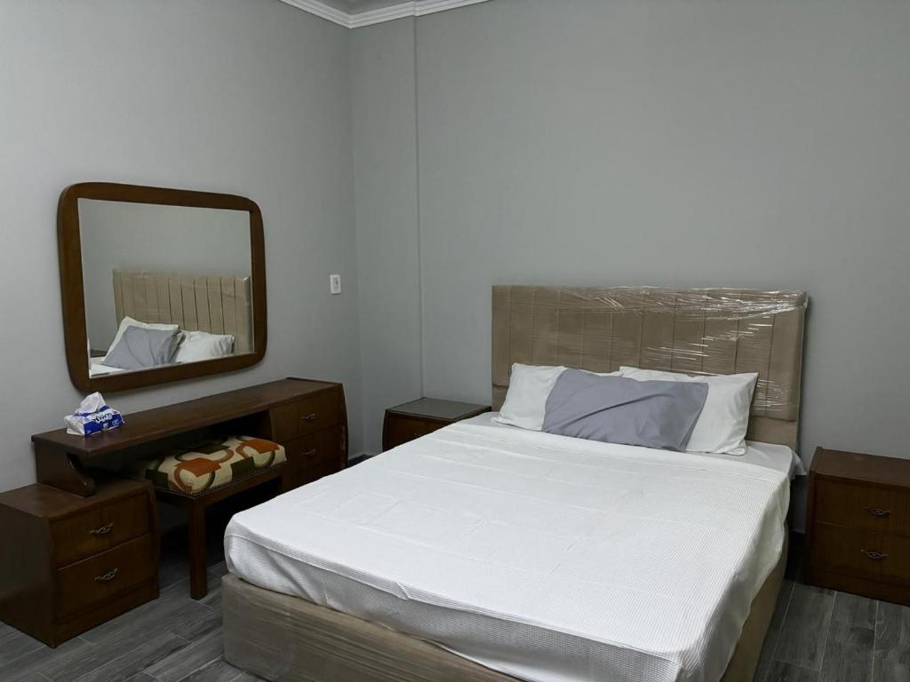 a bedroom with a large bed and a mirror at Heliopolis Residence Shorouk city, Cairo (premium) in Madīnat ash Shurūq