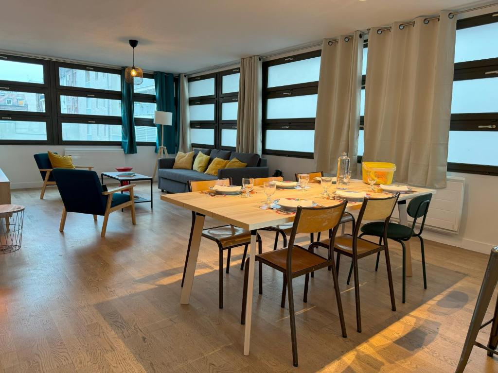 une salle à manger et un salon avec une table et des chaises dans l'établissement Appartement Loft Terrasse - Saint Denis, à Saint-Denis