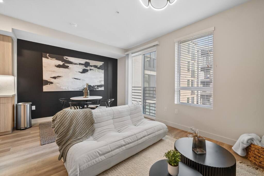 Una sala de estar con un sofá blanco y una mesa. en Luxury & Modern Irvine Apt, en Santa Ana