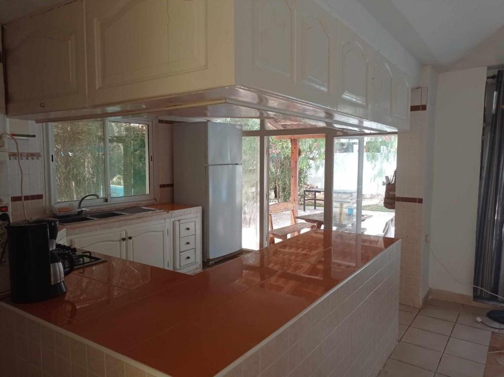 a kitchen with a counter top and a kitchen with glass at villa les oliviers in Port El Kantaoui