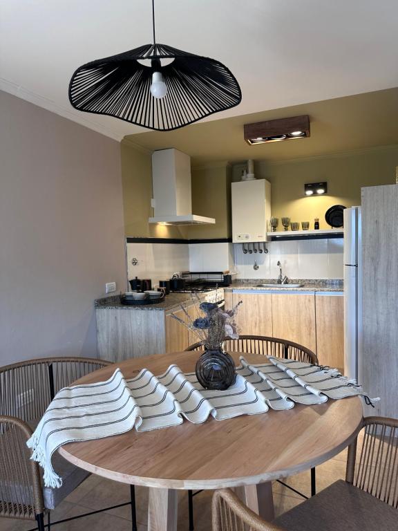 une table de salle à manger avec des chaises et une cuisine dans l'établissement Ginkgo Patagonia, à El Bolsón