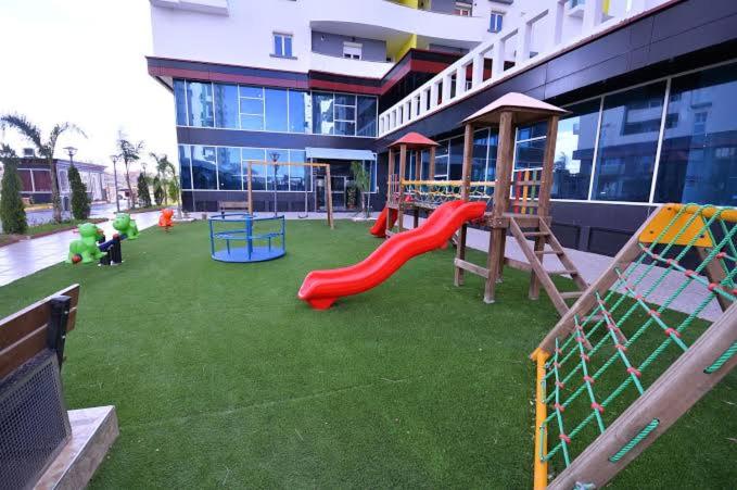 a playground in front of a building with a slide at Résidence El Manzeh in Oran
