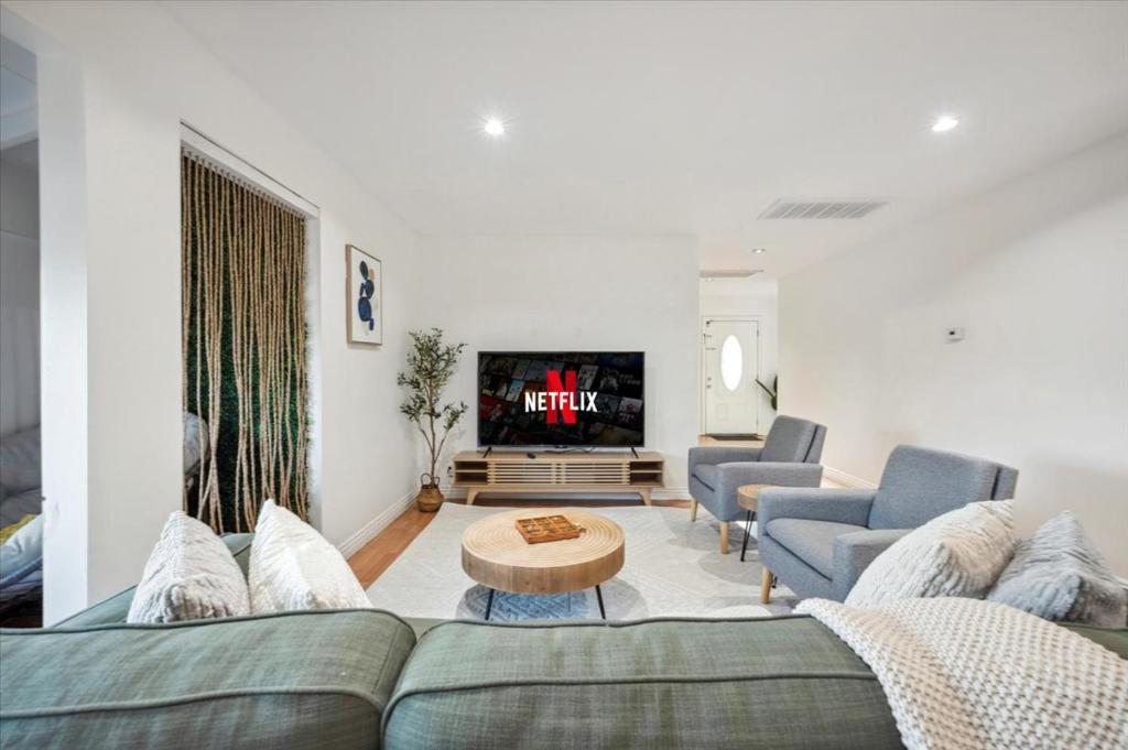 un soggiorno con un divano e una TV di Chic Boho Retreat - Pool, Spa, Patio, Mini Golf & Arcade, Mins from Universal Studios! a Los Angeles