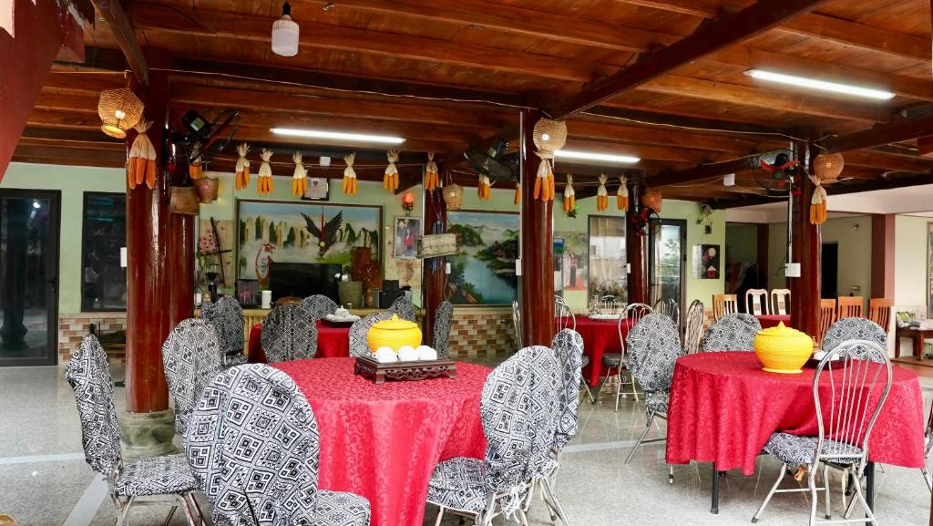 a dining room with red tables and chairs at Homestay Minh Ngọc in Ban Hin Lom