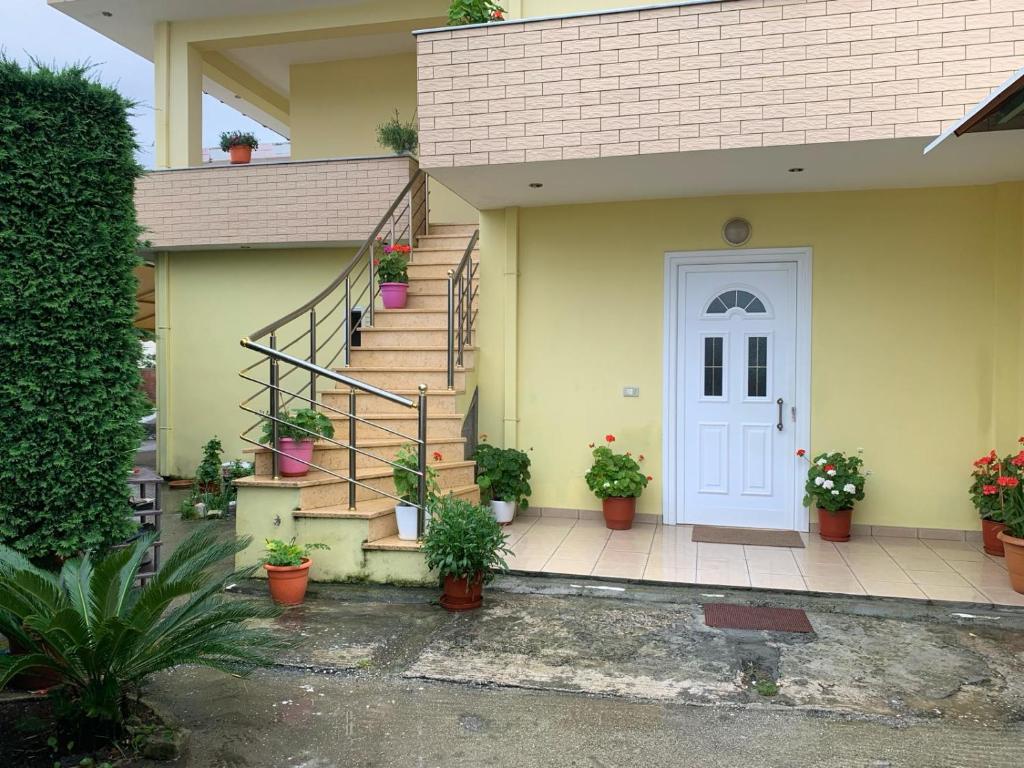 费里4 Bed Villa - Sleeps 9 - Pets - Garden - Parking的一栋房子，有着白色的大门和摆放着盆栽植物的楼梯。