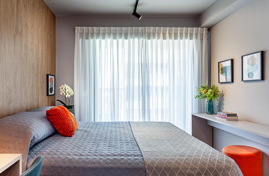 un dormitorio con una cama y una ventana en Studio Moderno com Piscina e Academia completa na Cobertura excelente espaço de Coworking Próximo ao Aeroporto de Congonhas e SP Expo, en São Paulo