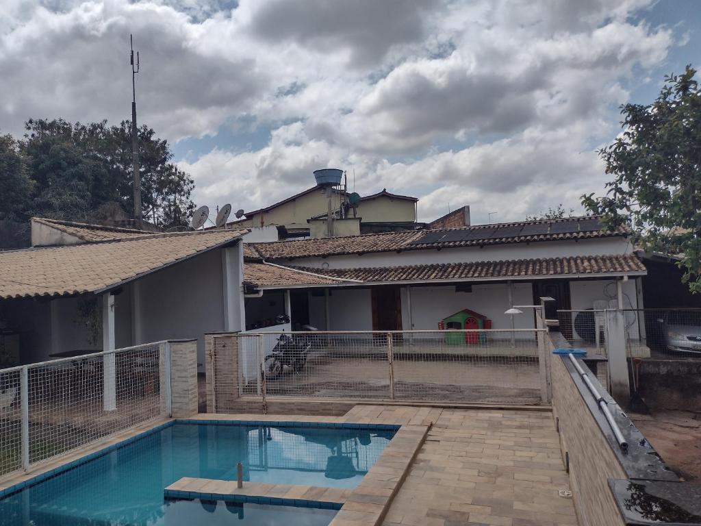 een huis met een zwembad ervoor bij Sítio do espeto in São José dos Salgados