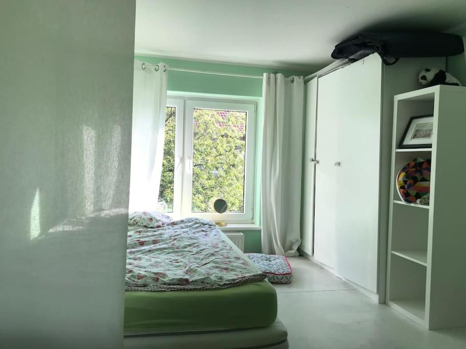 1 dormitorio con cama y ventana en Great cozy city apartment self check in, en Hannover
