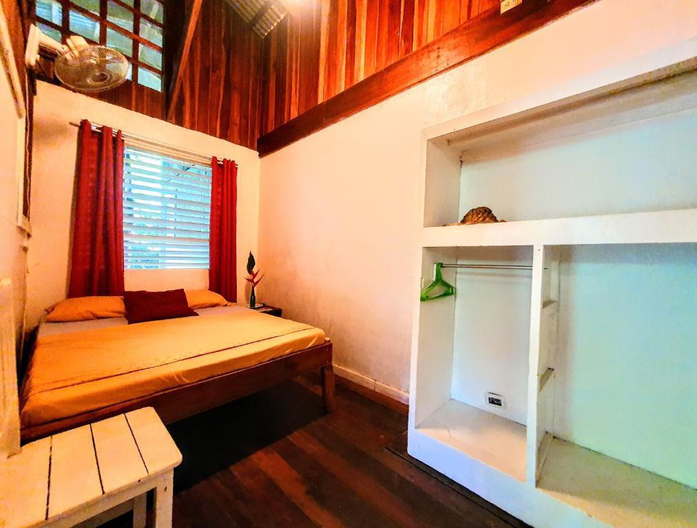 Habitación pequeña con cama y ventana en Arana House, en Puerto Viejo