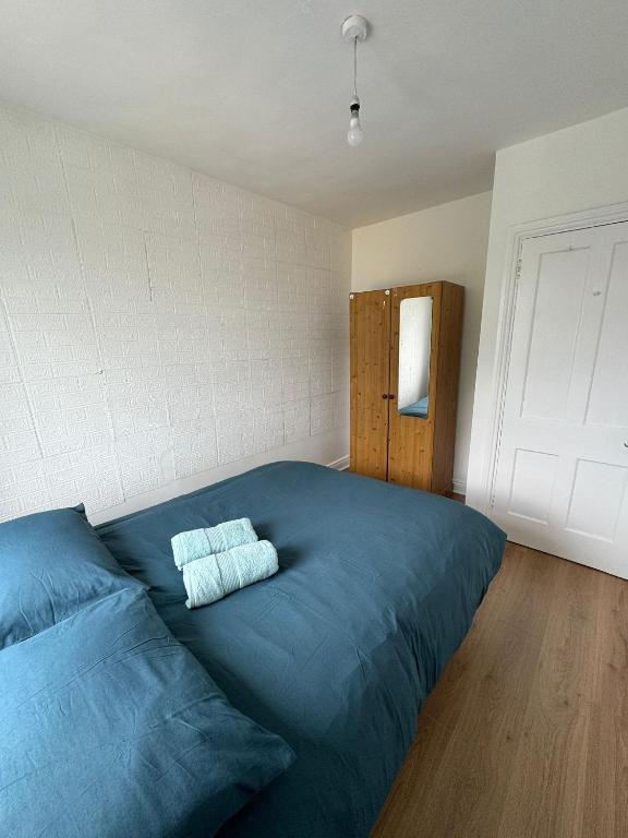 a bedroom with a blue bed with two towels on it at Nice Double Room at 2 Iveragh Rd-8 in Dublin