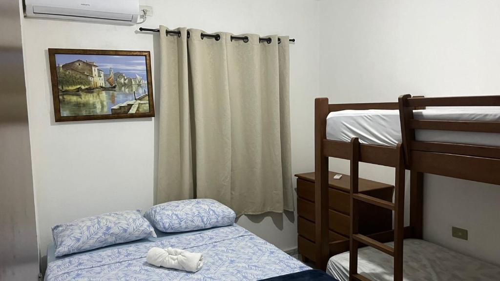 a bedroom with a bed and a bunk bed at Condomínio Enseada dos Corais apto completo in Cabo de Santo Agostinho
