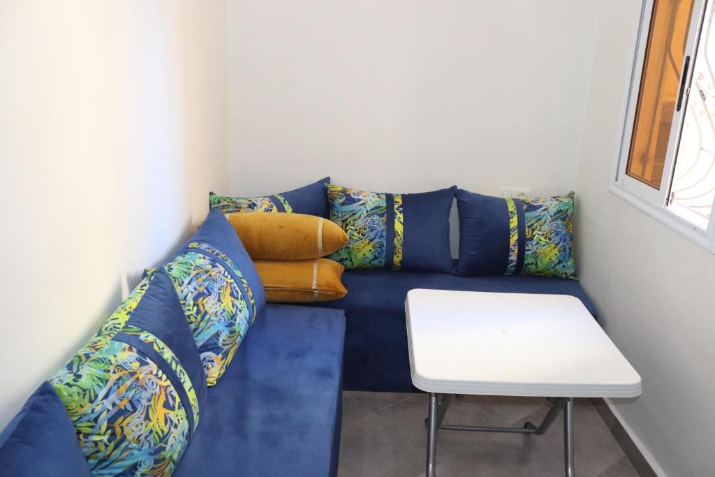 a blue couch with pillows and a white table at Taghazout Flats in Taghazout