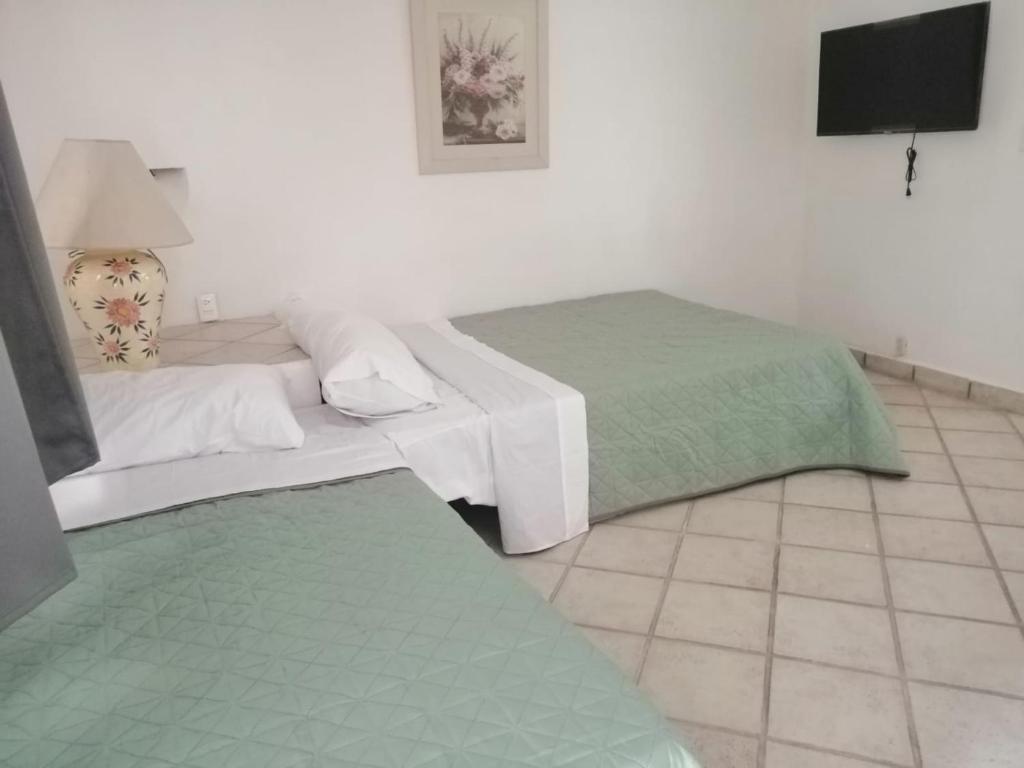 a bedroom with two beds and a flat screen tv at Majaguar in Cancún