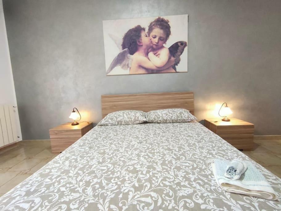 een slaapkamer met een groot bed met 2 lampen bij Casa a Matrice a Barrafranca in Barrafranca