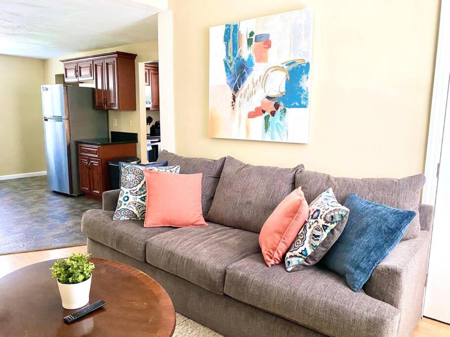 a living room with a couch with pillows on it at Comfy Easeful Two Bed Apartment 30 min to Boston in Brockton