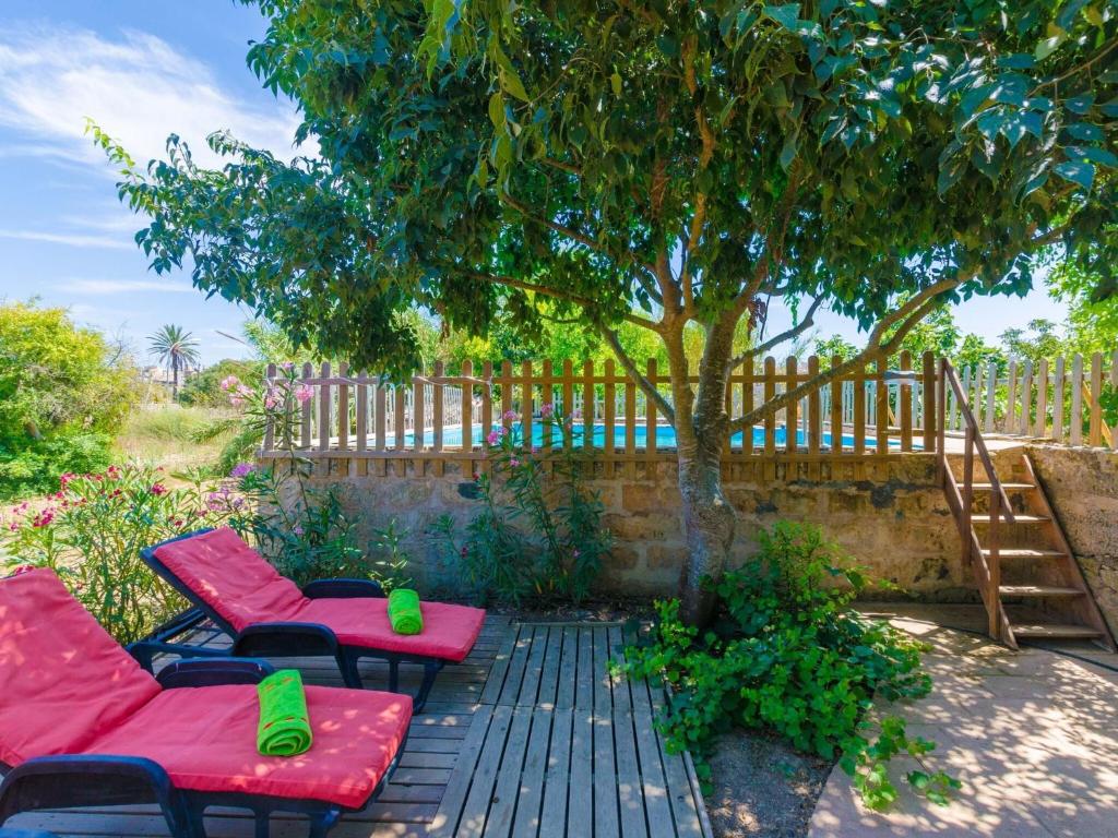 une terrasse avec deux chaises rouges et un arbre dans l'établissement Hort De Can Bou - Villa With Private Pool In Porreres Free Wifi, à Porreres