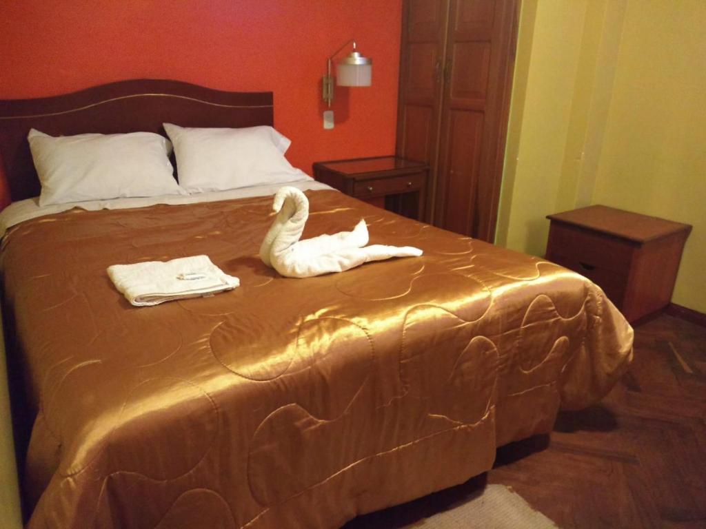 a stuffed swan on a bed in a bedroom at PUNO EROPA HOTEL in Puno