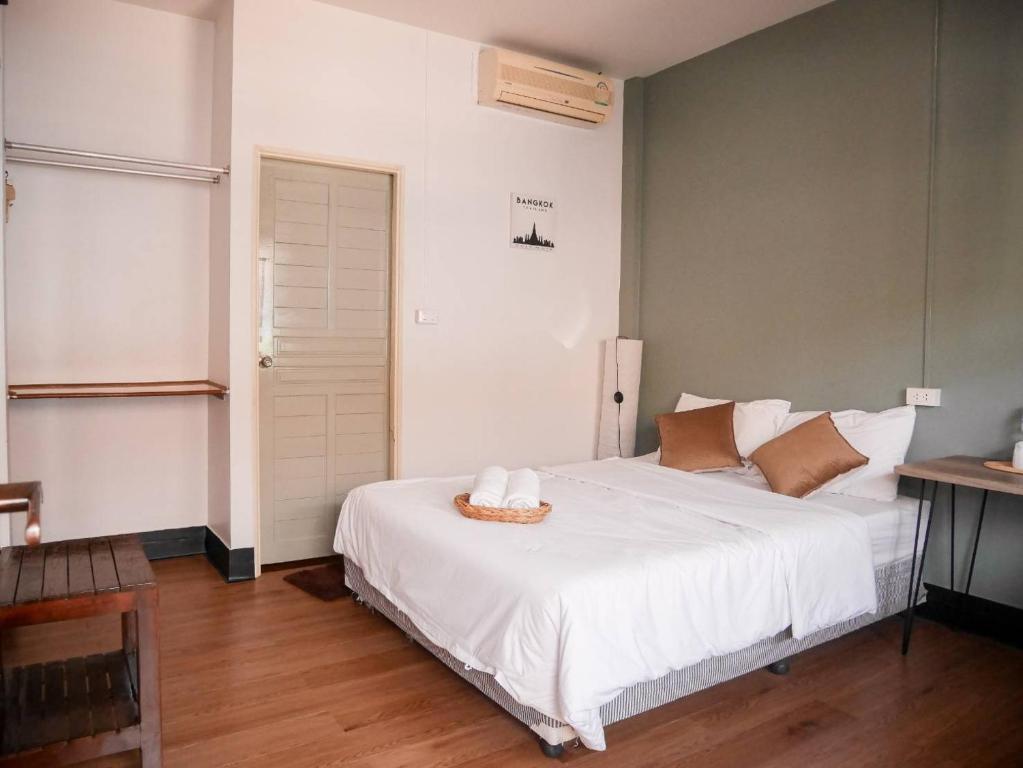 a bedroom with a white bed with a basket on it at Orchid house in Chiang Rai