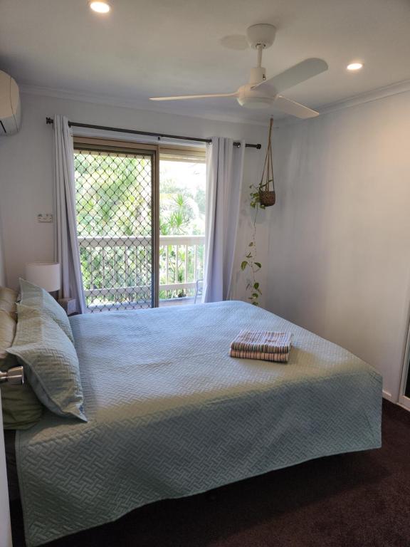 een slaapkamer met een groot bed en een raam bij One room for two with a kitchenette,lounge and bathroom downstairs in Ocean Shores