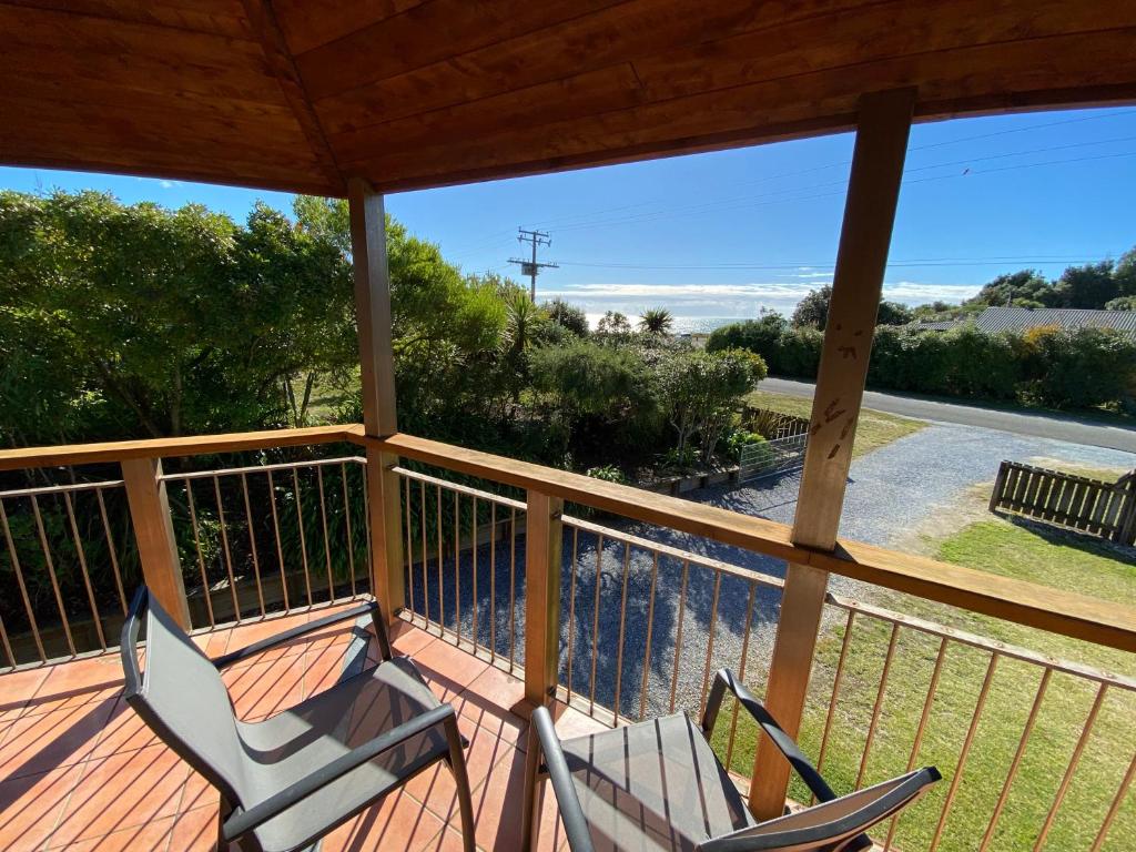 two chairs on a porch with a view of the ocean at Pohara Tides - Poharas Beach Getaway in Pohara