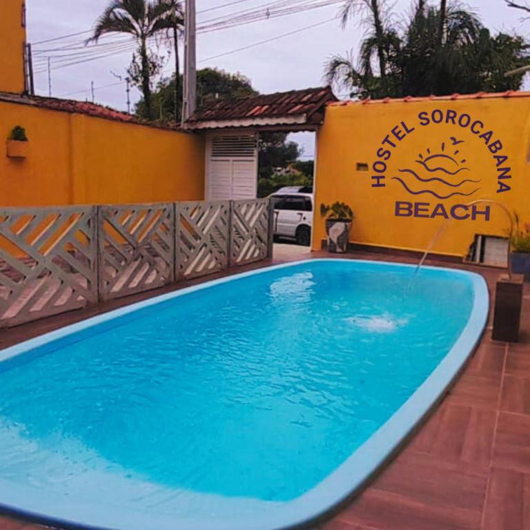 una piscina frente a una casa de playa en Hostel Sorocabana Beach, en Itanhaém
