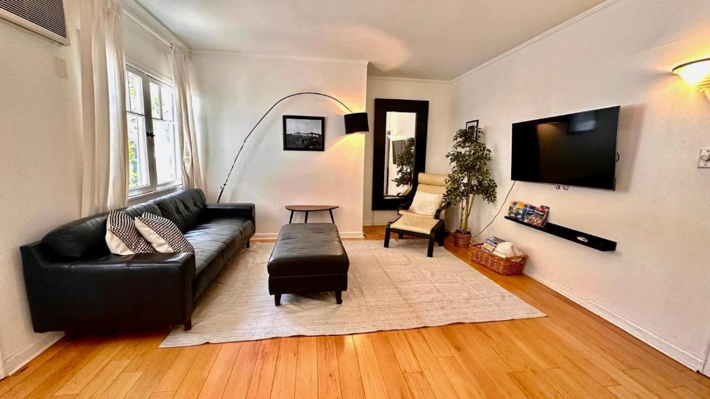 uma sala de estar com um sofá de couro preto e uma mesa em Echo Park Hills em Los Angeles