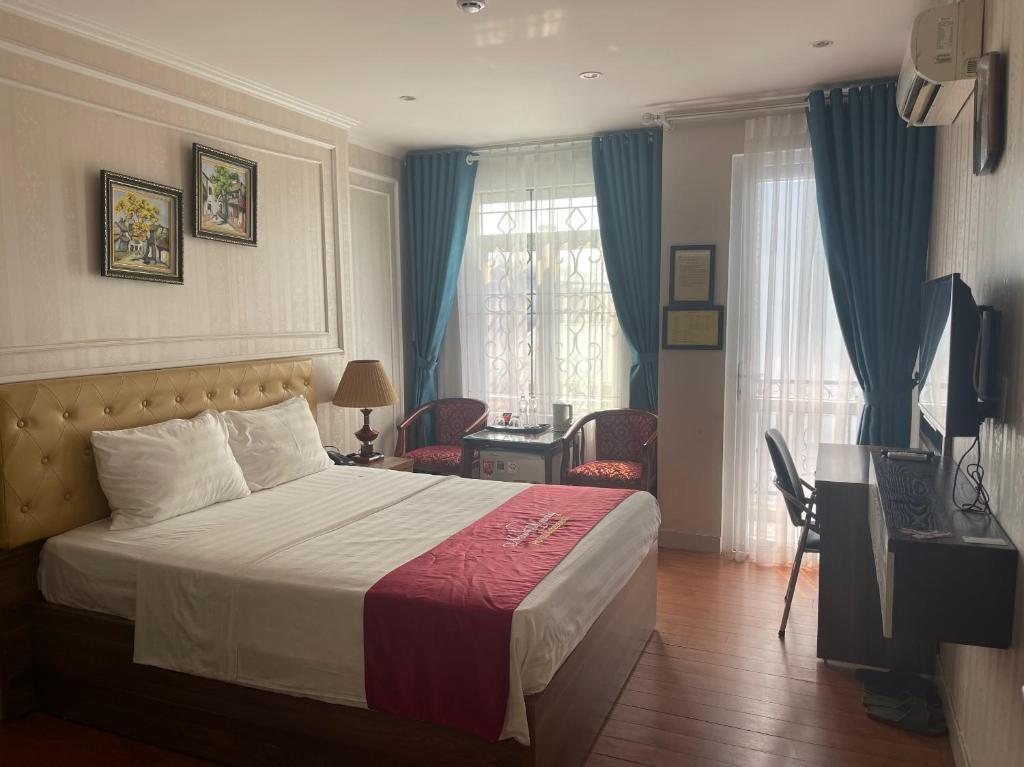 a bedroom with a bed and a desk and a television at New Amely Hotel in Hanoi