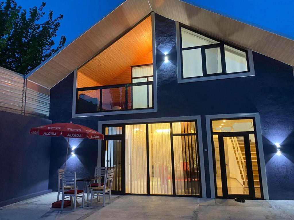 une maison avec une table et des chaises devant elle dans l'établissement Sheki Guest Villa, à Shaki