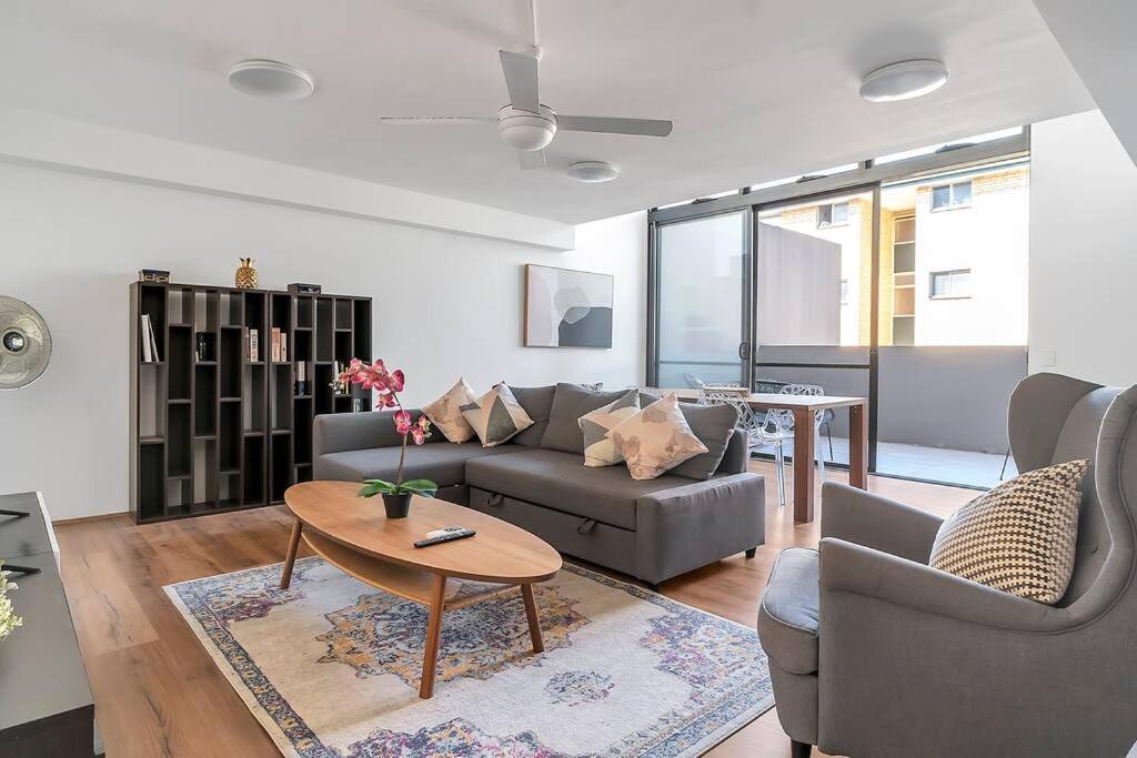 ein Wohnzimmer mit einem Sofa und einem Tisch in der Unterkunft 'The Abstract at Kingsford' Spacious and Sunny Stay in Sydney