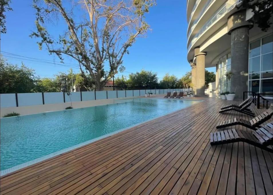 - une piscine avec bancs sur une terrasse en bois dans l'établissement Torre Golden 8Pax By Inside, à Mendoza