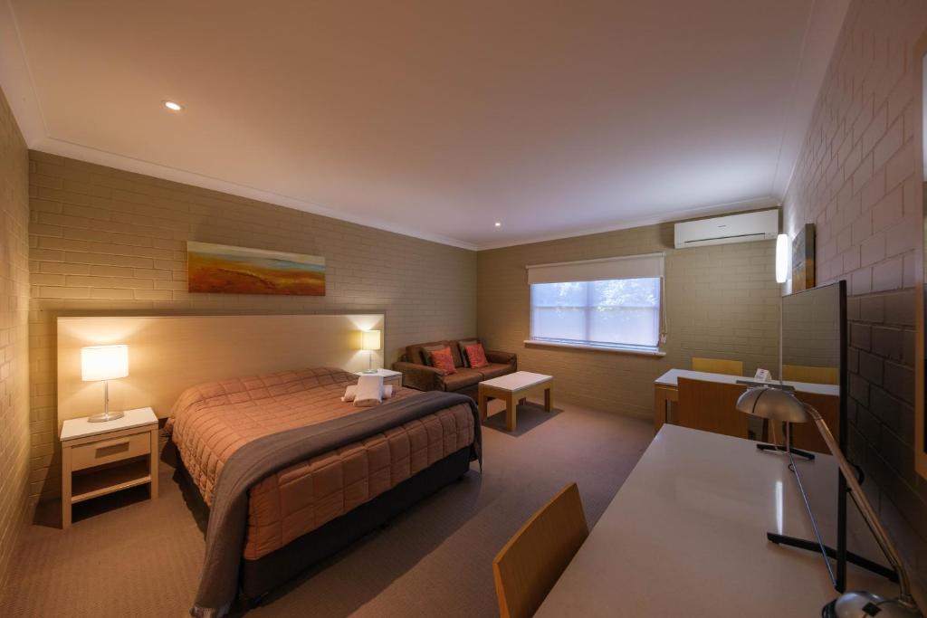 Habitación de hotel con cama y sofá en Imperial Motel, en Bowral