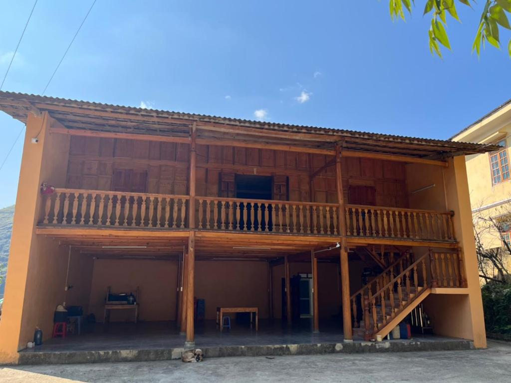 Casa con terraza de madera y mesa en Hương Đồng Homestay, en Dồng Văn