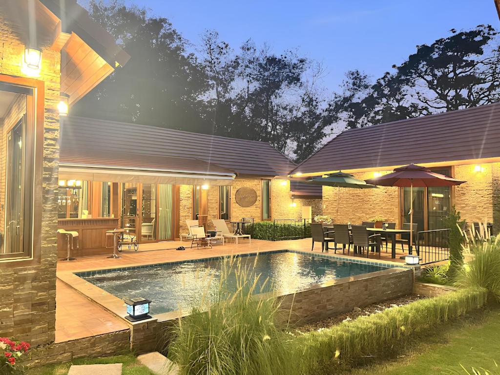 un patio trasero con piscina y una casa en Bella Vista Khao yai en Ban Muak Lek Nai