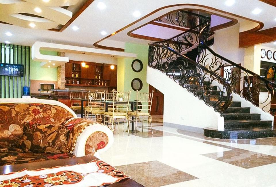 a living room with a couch and a spiral staircase at RedDoorz at Nick Hotel Isabela 